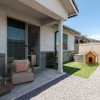 a backyard with a dog house and patio furniture