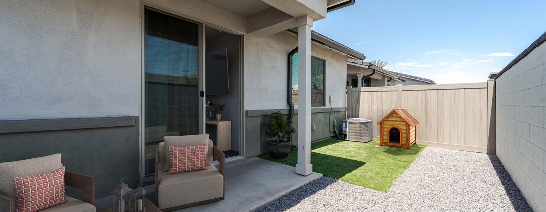 a backyard with a dog house and patio furniture