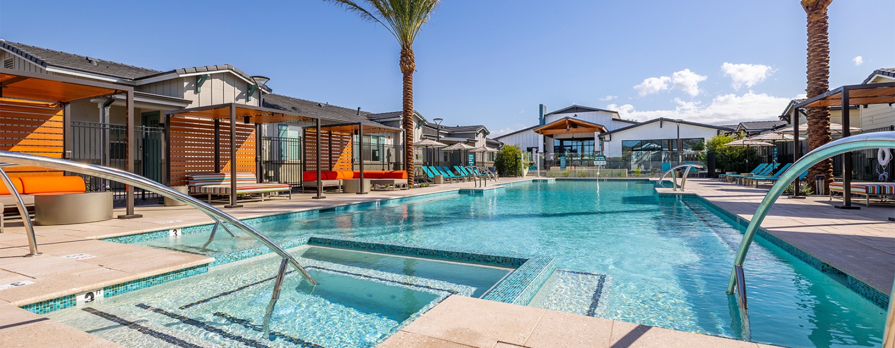 a pool surrounded by cabanas and palm trees